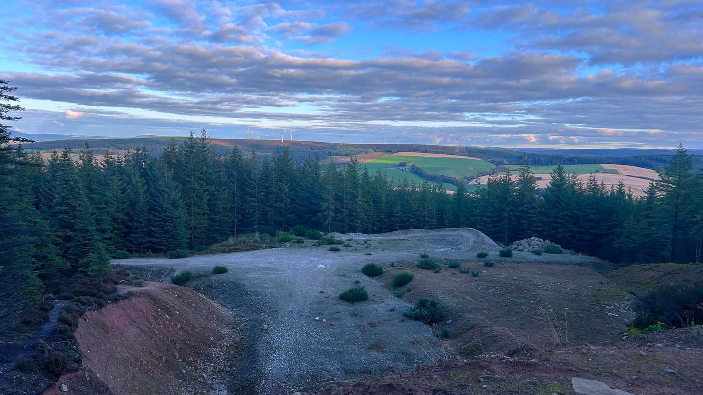 The view from the top of the quarry path — windmills on the ridge and farmland below