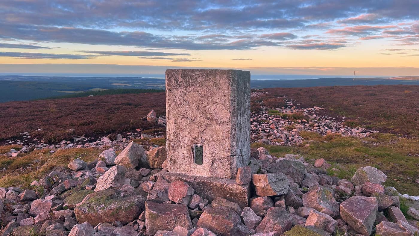 The trig point on its pile of pink stone, the Moray Firth along the horizon