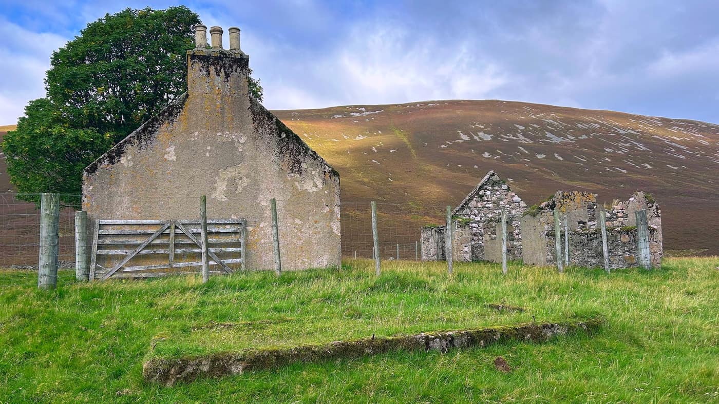 The second ruin behind it — one gable and its chimney pots still standing, the rest open to the sky