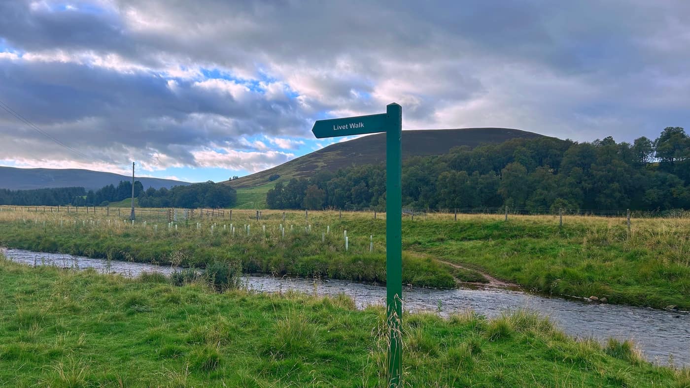The Livet Walk sign beside the bridge, with the hill behind