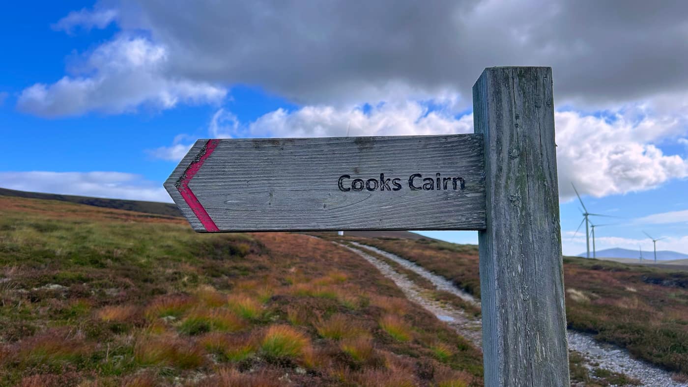 The sign up close — Cooks Cairn, red chevron on the end