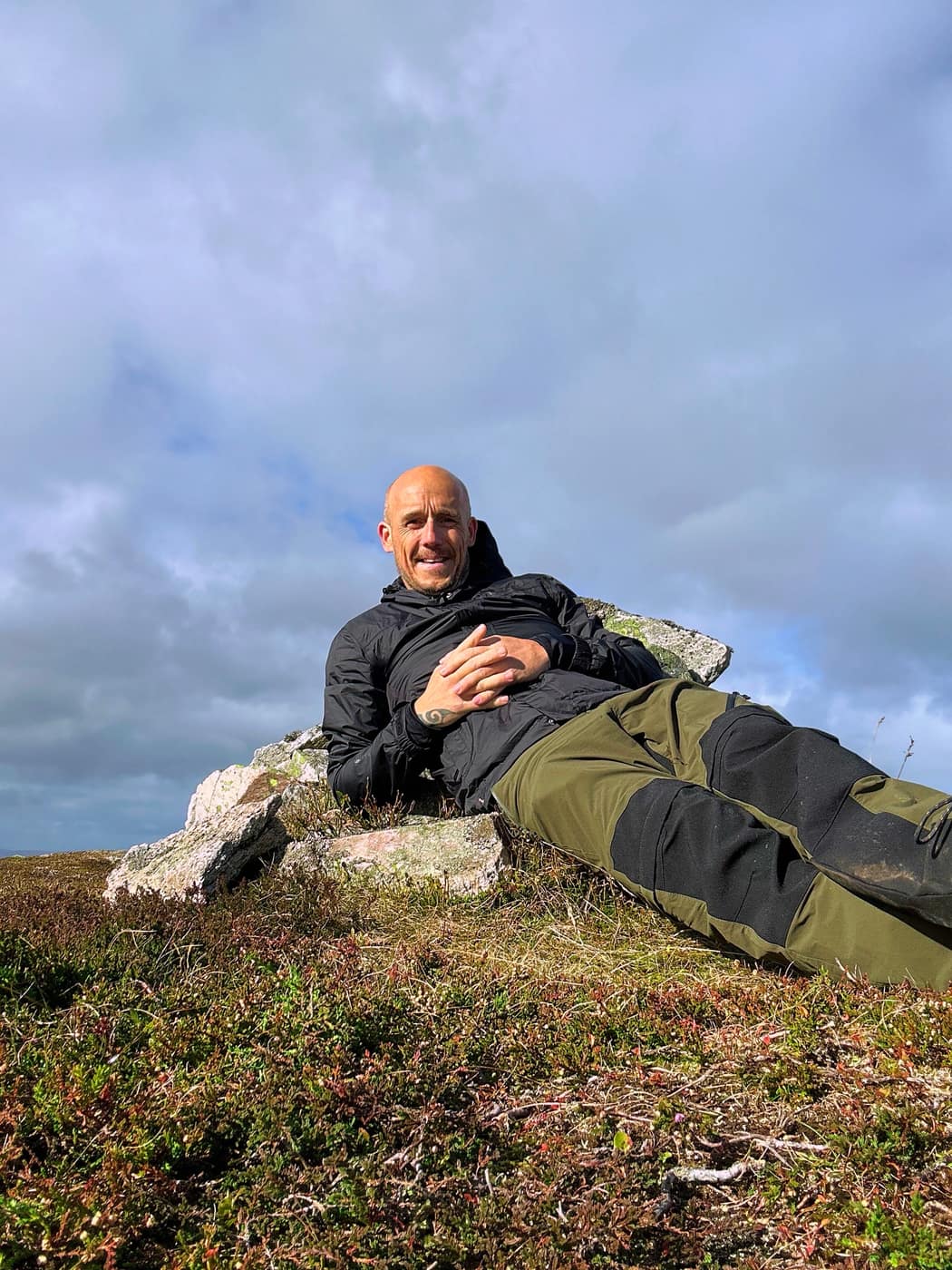 Me lying back against the cairn stones at the top