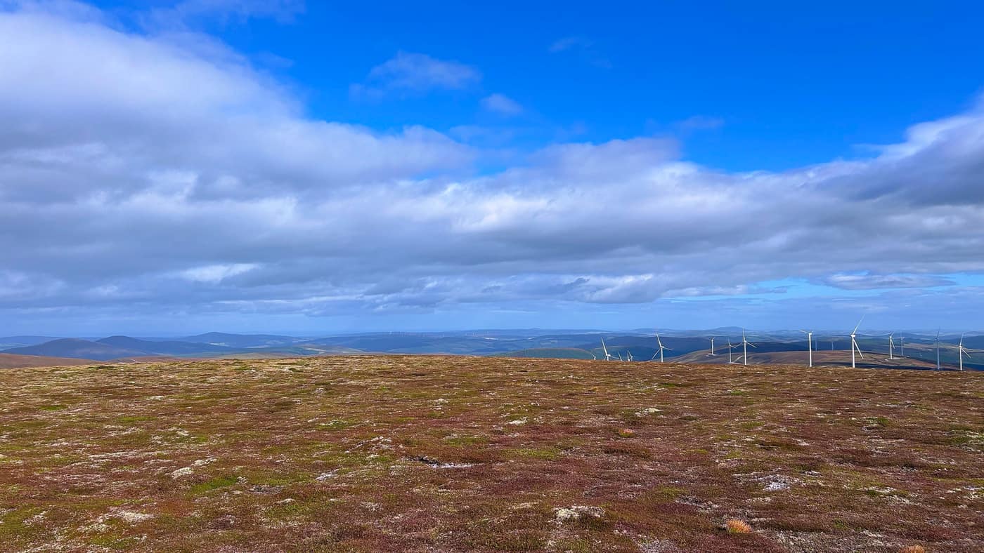 The broad summit plateau, the wind farm away to the right