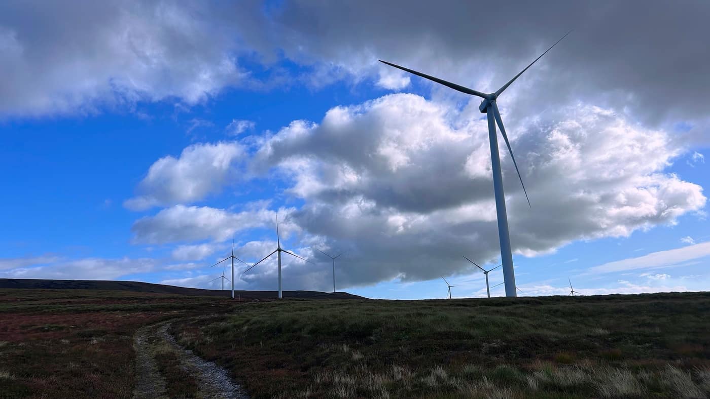 The wind farm on the ridge, the path curving in below the big one