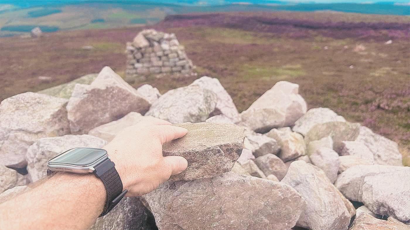 Putting a stone on the summit cairn