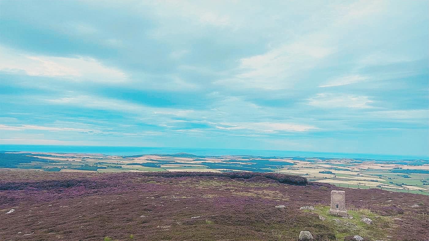 The summit plateau with the trig point and the sea beyond