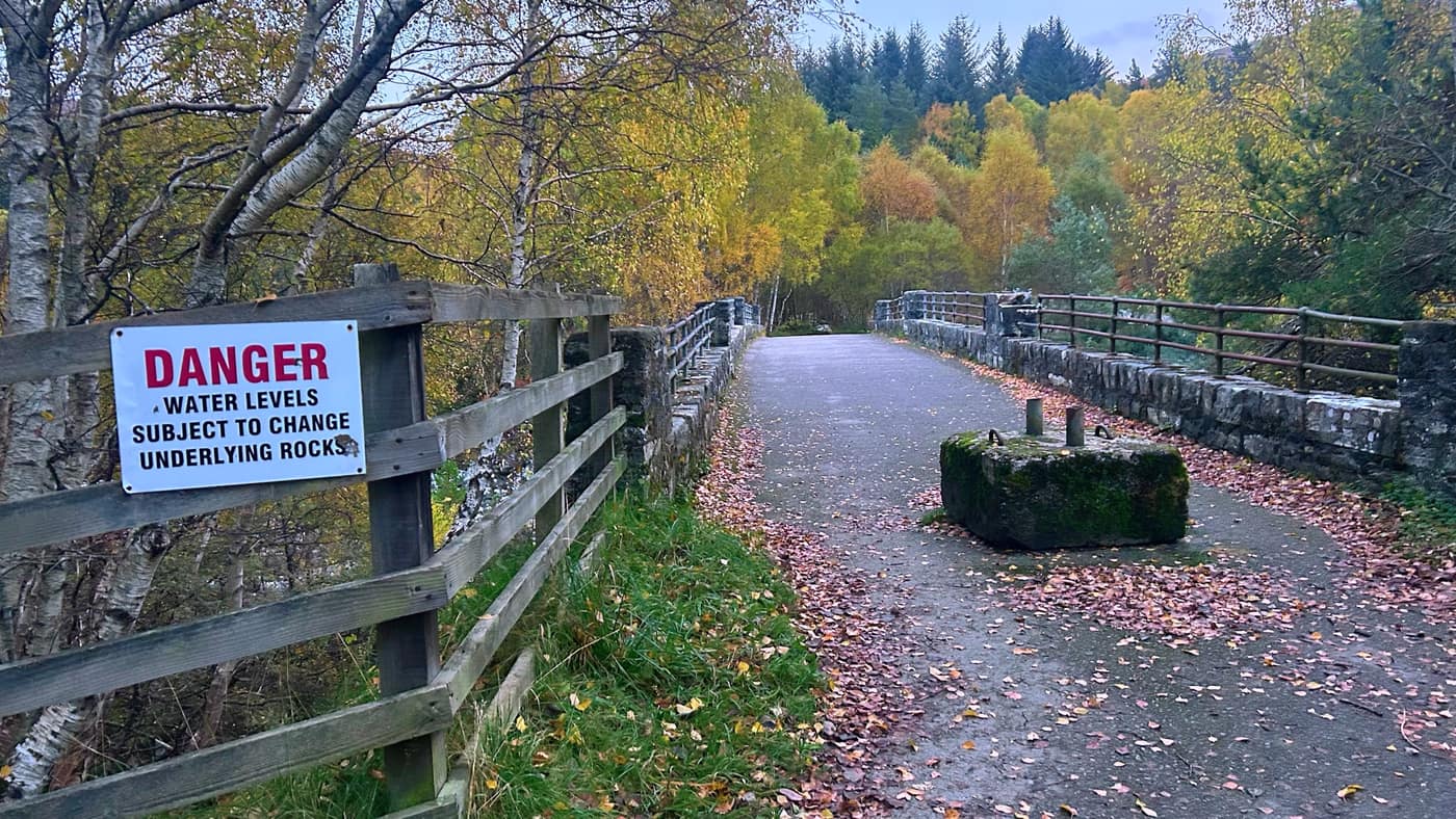 The old stone bridge over the Black Water, with a danger sign about changing water levels