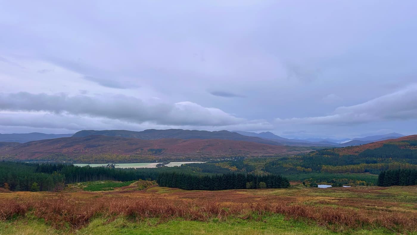 The look back down the valley, forest and fields with hills behind