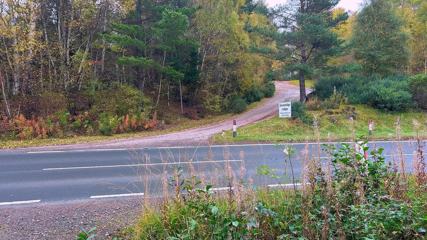 The A835 and the track on the far side, beside the Silverbridge Lodges sign