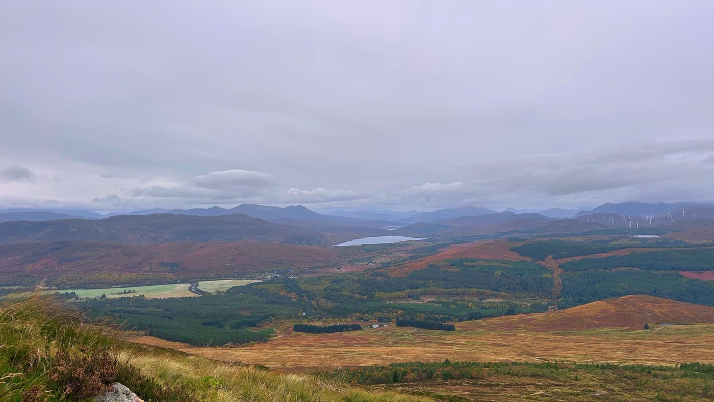 A loch in the valley below, windmills on the hills beyond