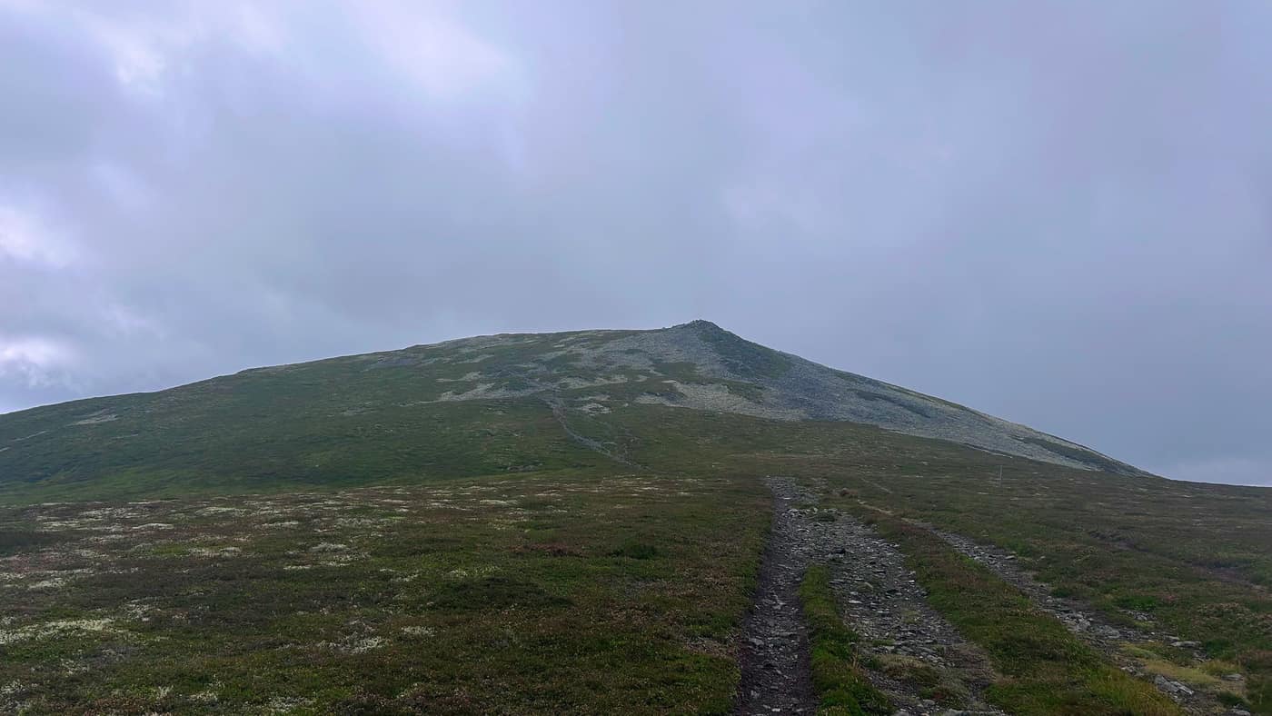 A cone with a cairn on top of it, which is not the summit