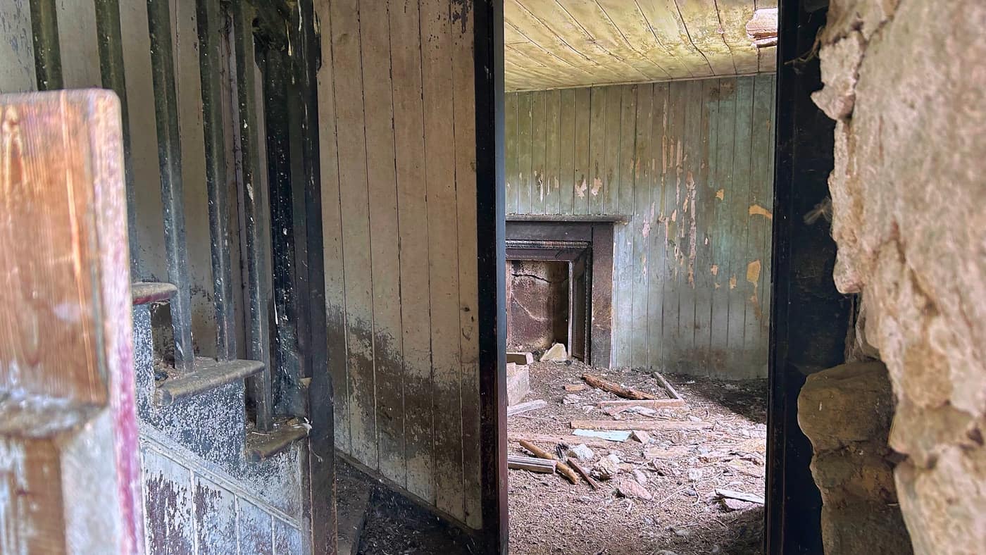 Through a doorway into the next room, panelling still on the walls