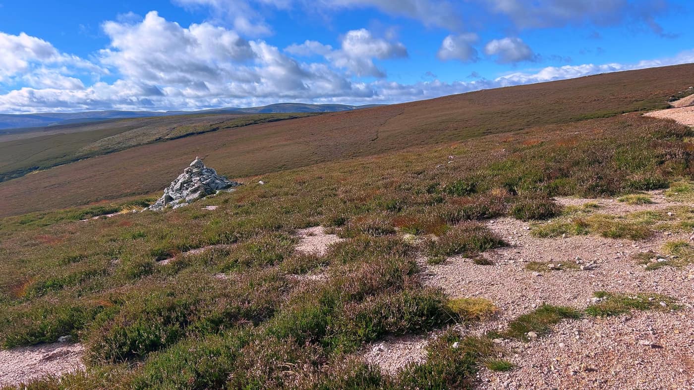 The cairn on the left of the path at the crossroads