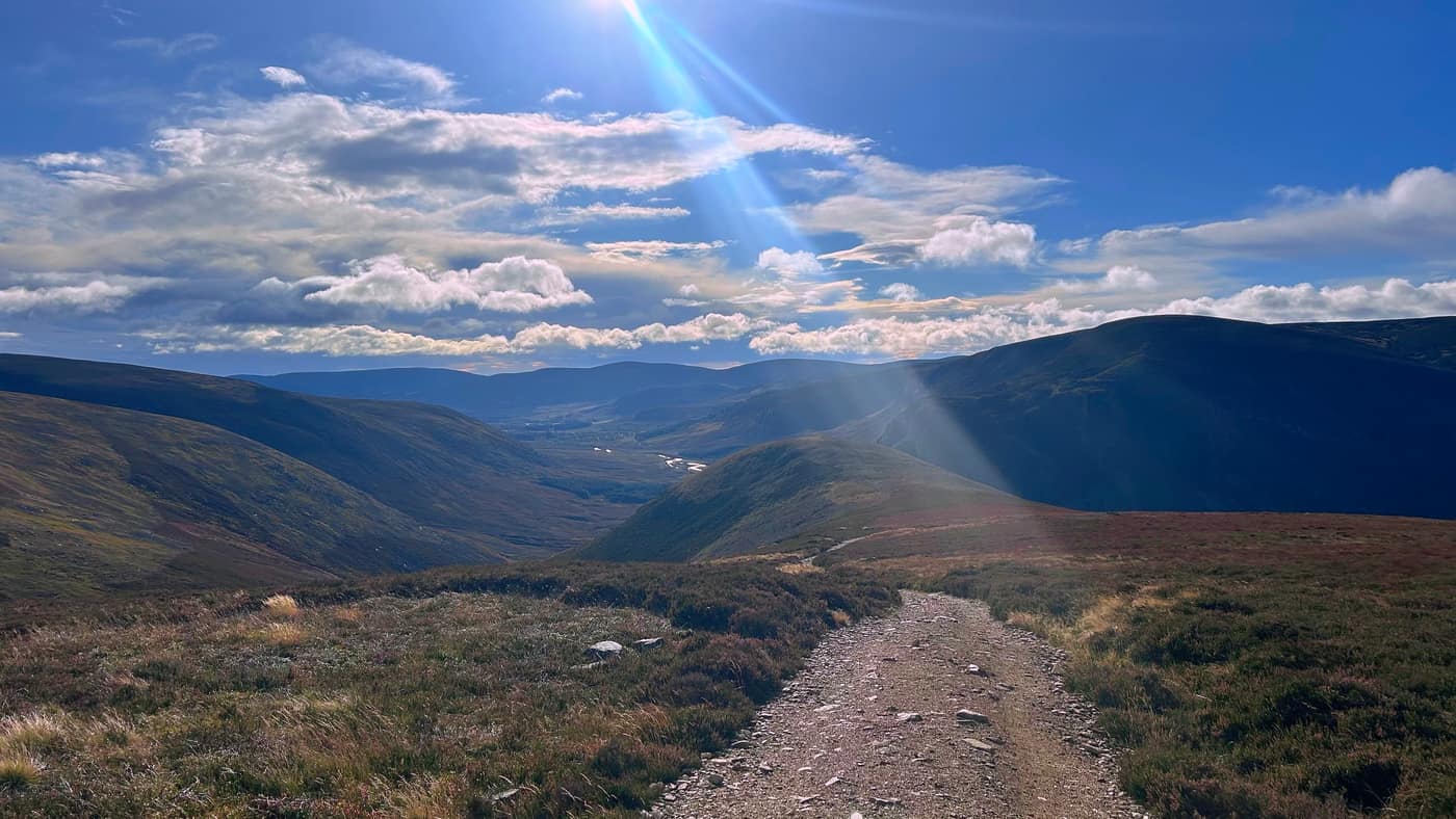 The track levelling onto the open moor, the sun breaking through over the glen