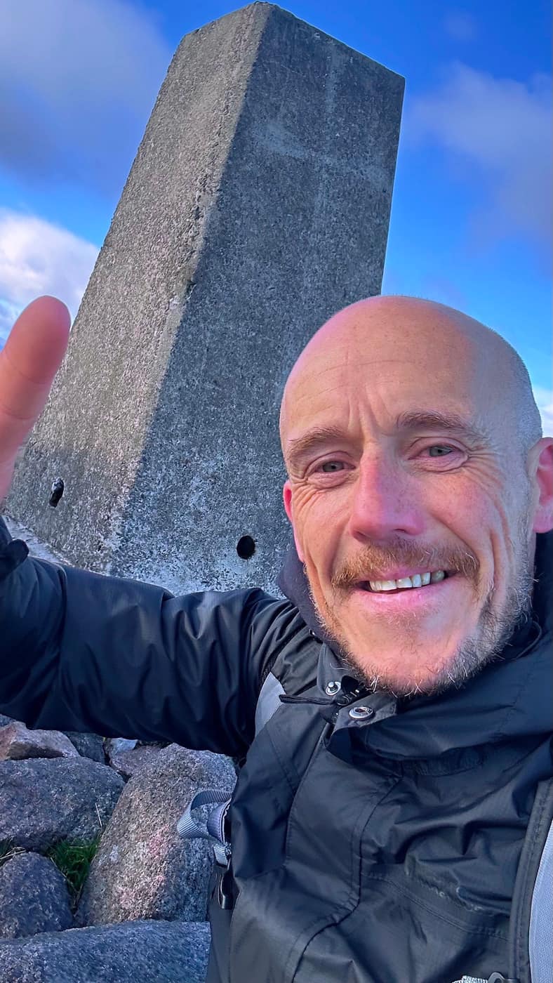 Ross at the trig point on Mount Keen
