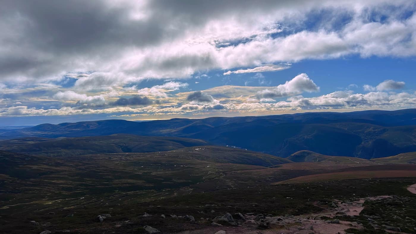The view from the summit over the moors, the sea catching the light on the horizon