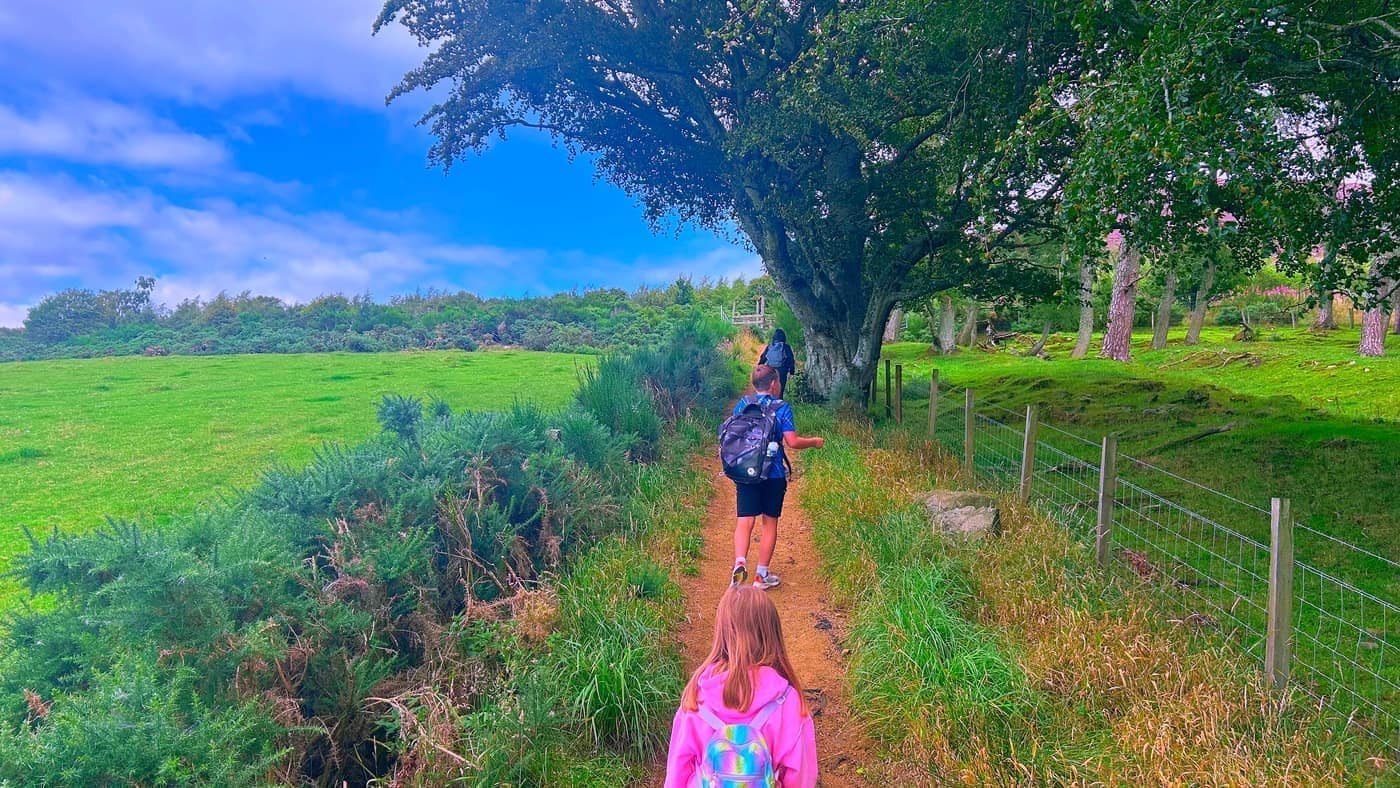 The kids heading up the narrow sandy path