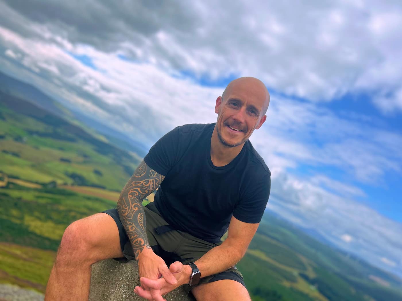 Me on the trig point with the hill dropping away behind