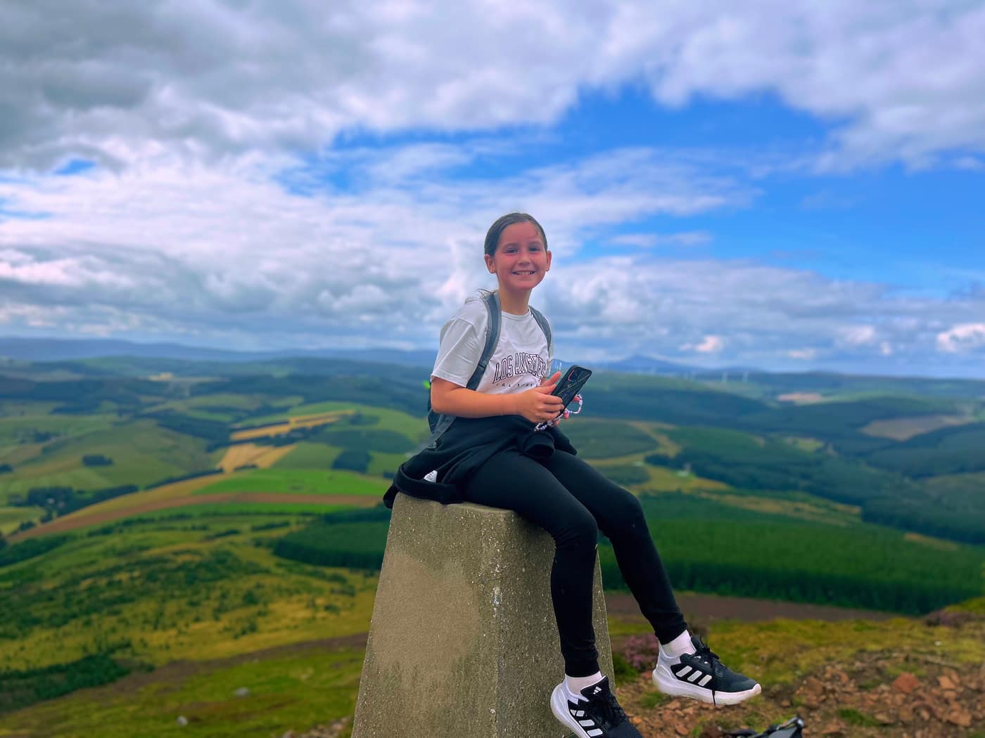 Sat on the trig point with the fields behind