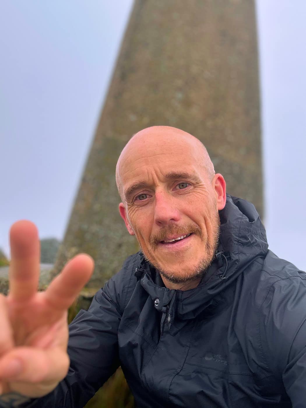 Me at the trig point in the mist, hood up